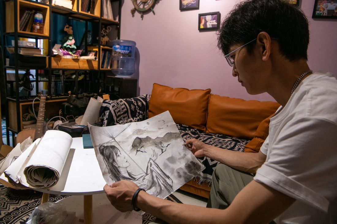 劉志誠在家中構思牆繪草稿（6月25日攝）。