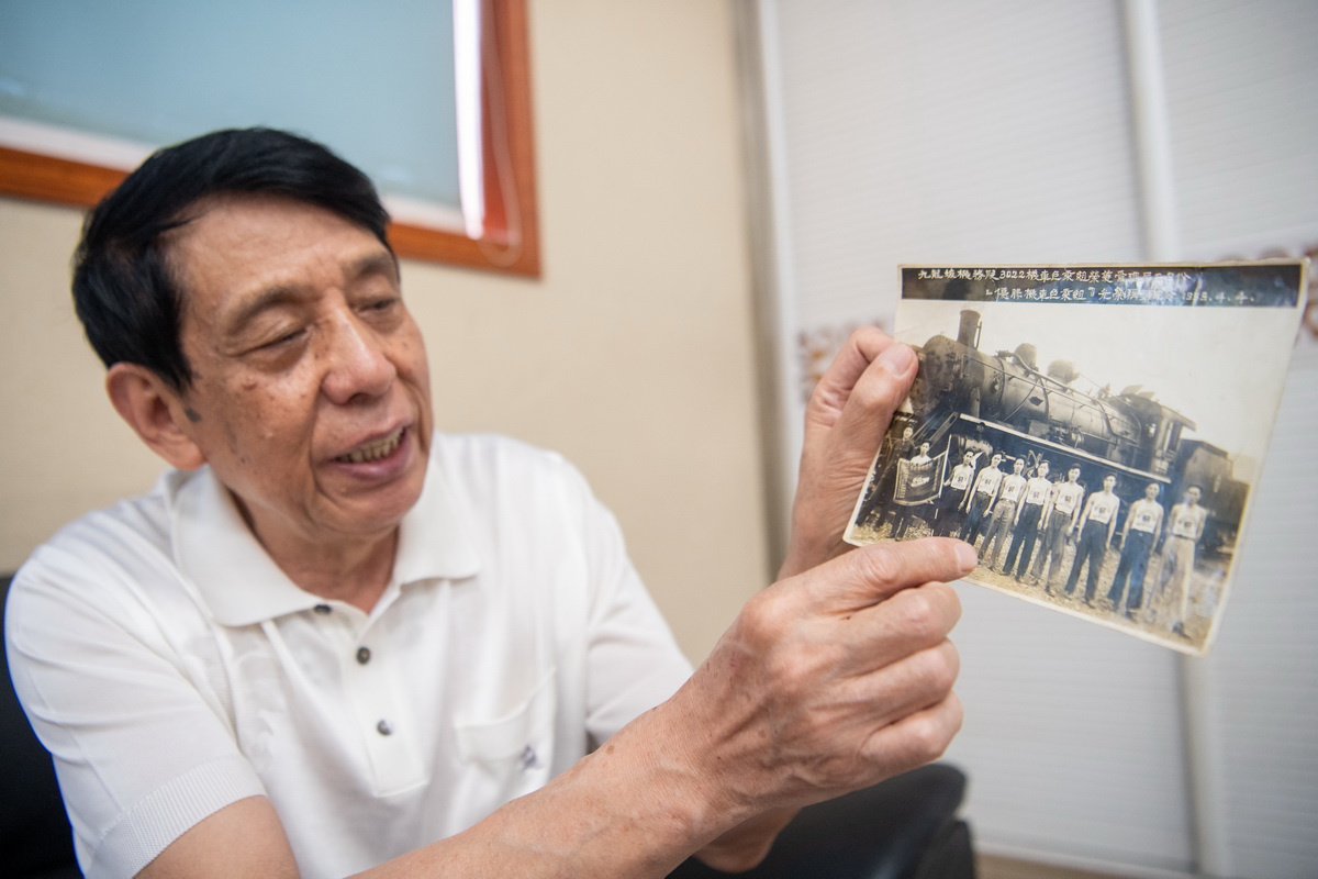 6月29日，在重慶西動車所，李治剛的父親李國方手拿老照片，講述成渝鐵路列車的故事。新華社記者 唐奕 攝