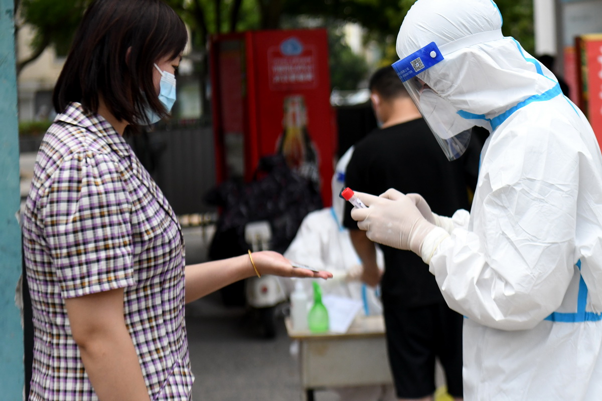 7月3日，在安徽省宿州市泗县虹城街道一小区，工作人员为居民登记核酸采样信息。