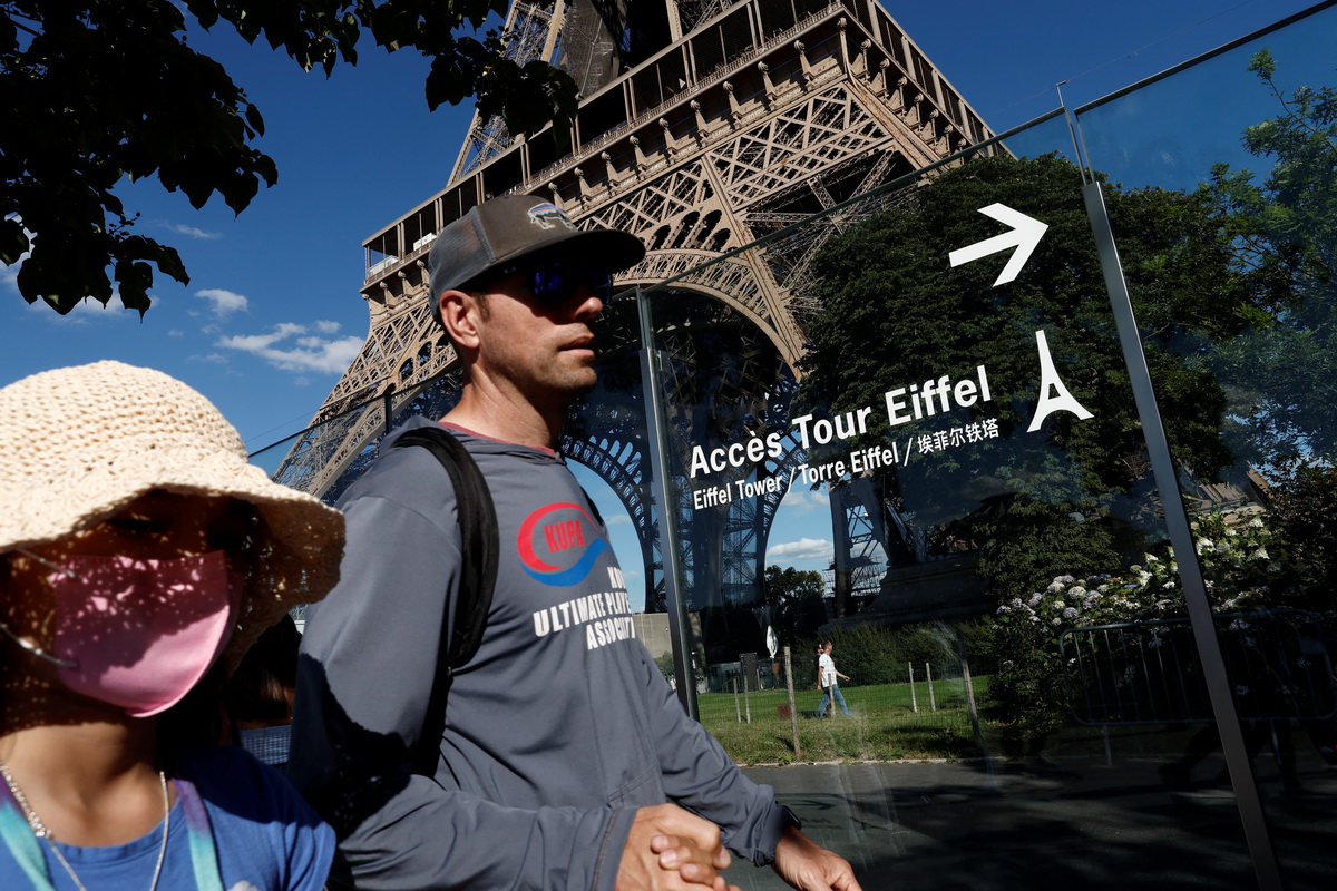 7月3日，人们走过法国巴黎的埃菲尔铁塔。