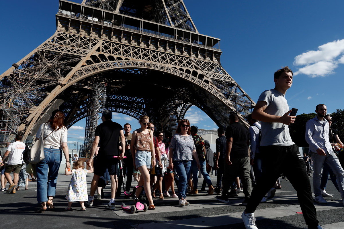 7月3日，人们走过法国巴黎的埃菲尔铁塔。