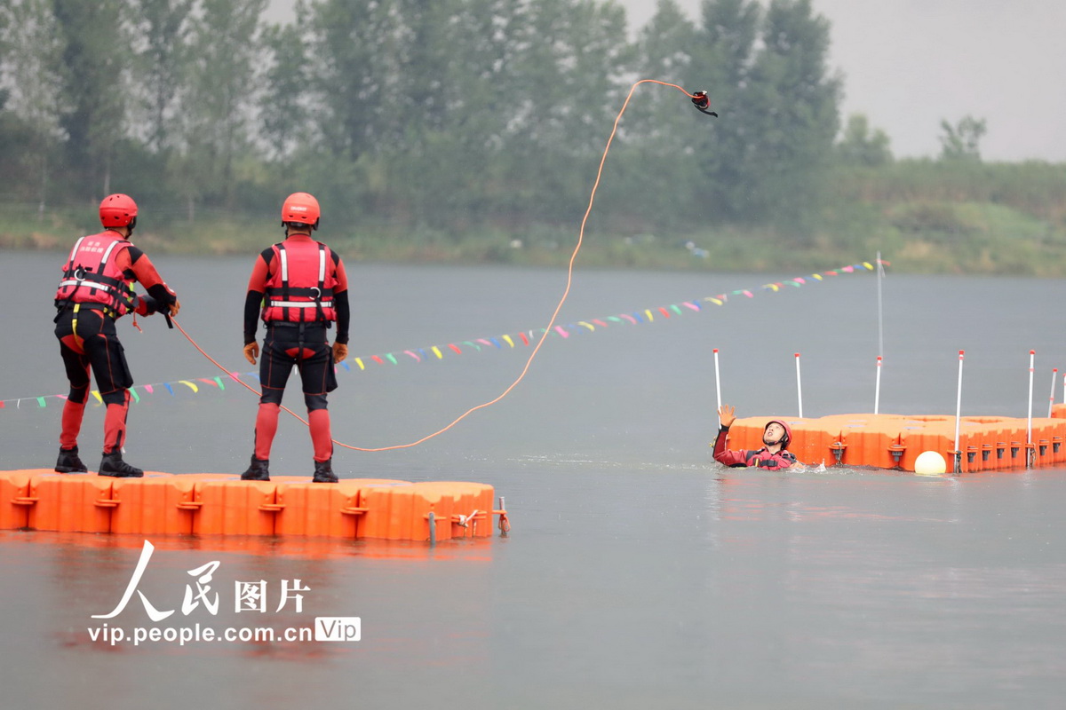 2022年7月7日，湖南省消防救援總隊水域救援技術交流賽在常德柳葉湖舉行。圖為消防員在水中蛟龍項目比賽中進行拋繩包救援。