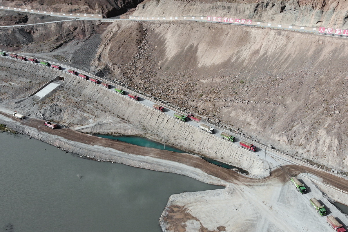 7月27日，為新疆大石峽水利樞紐工程運送填筑物料的車隊排成一條“長龍”（無人機照片）。