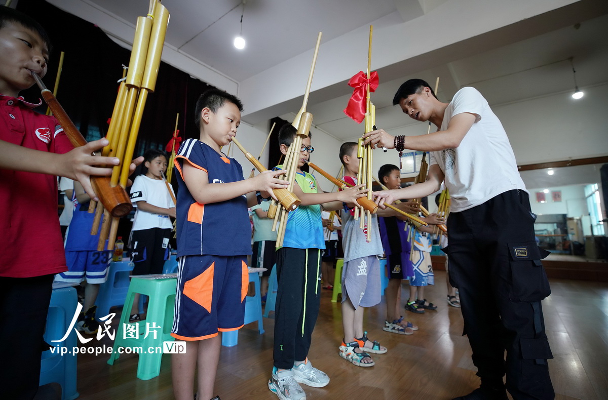 2022年8月1日，文化志願者在貴州省黔東南苗族侗族自治州丹寨縣文化館指導小朋友練習苗族蘆笙吹奏。