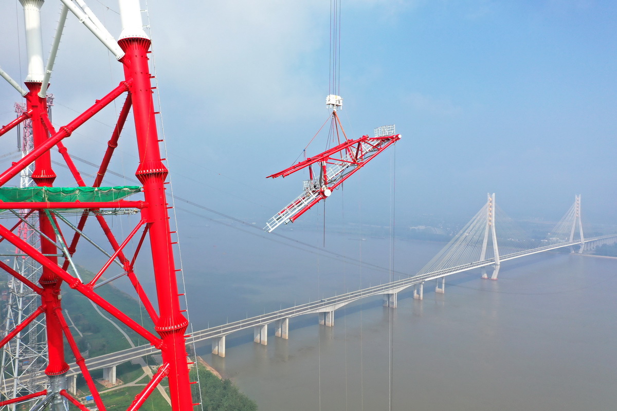 8月1日，安徽送變電工程有限公司施工人員在池州長江大跨越南岸跨越塔封頂施工現場作業（無人機照片）。