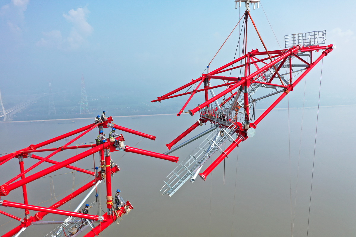 8月1日，安徽送變電工程有限公司施工人員在池州長江大跨越南岸跨越塔封頂施工現場作業（無人機照片）。