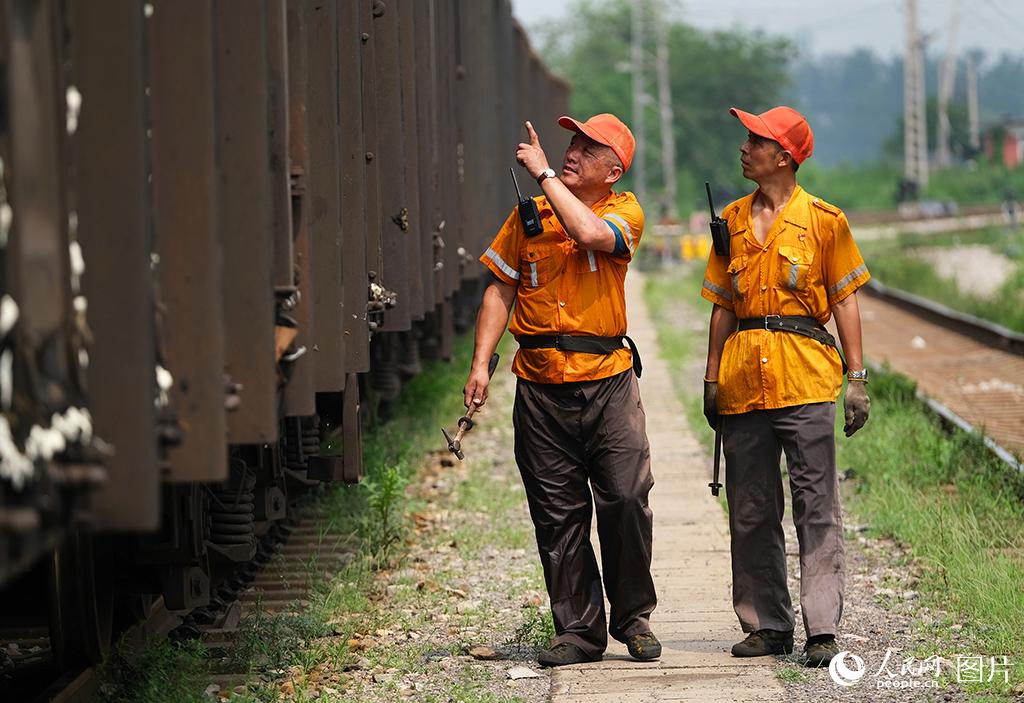 8月4日，酷暑下铁路天津车辆段检车人员在车辆现场进行检车作业。杨宝森摄