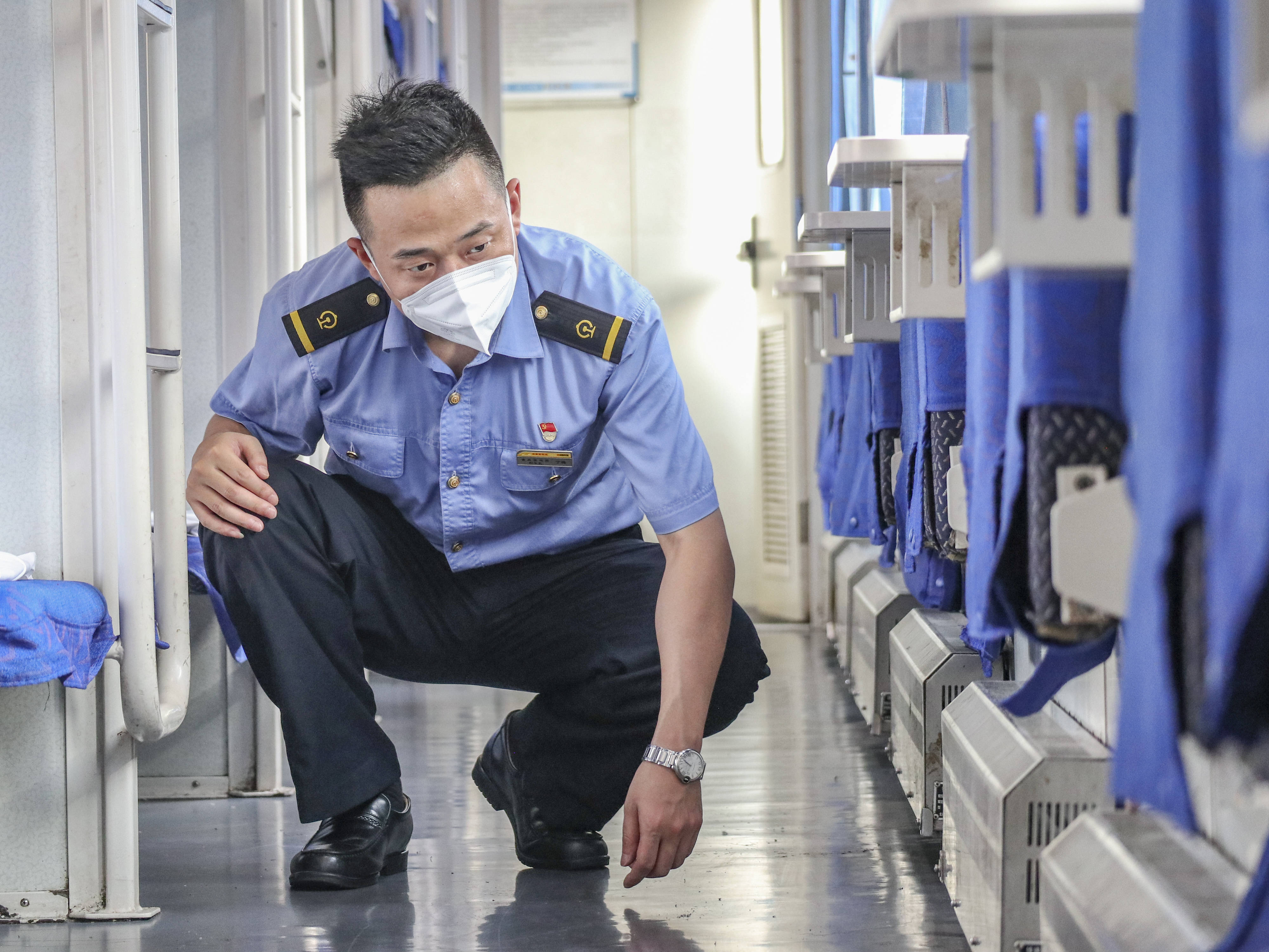 8月5日，在重庆西客车整备所，守车车长丁璐在库内对K1153次列车全列隐蔽部位进行检查。