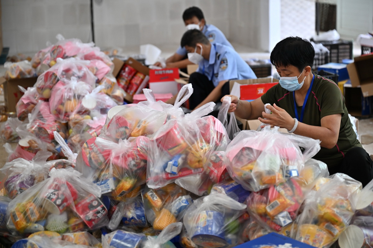 8月8日，在三亞一個物資倉庫，來自三亞各單位的工作人員將政府籌集的生活物資打包，准備送往游客入住的酒店。