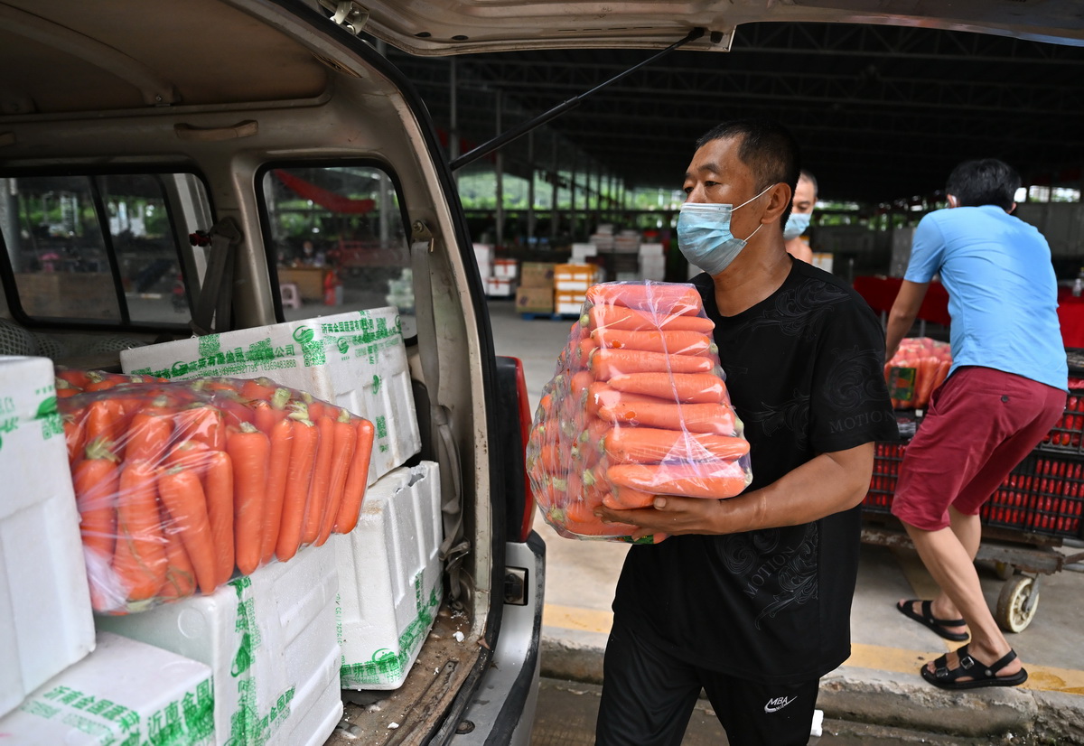8月8日，在三亞一農副產品批發市場，工作人員在裝運蔬菜。