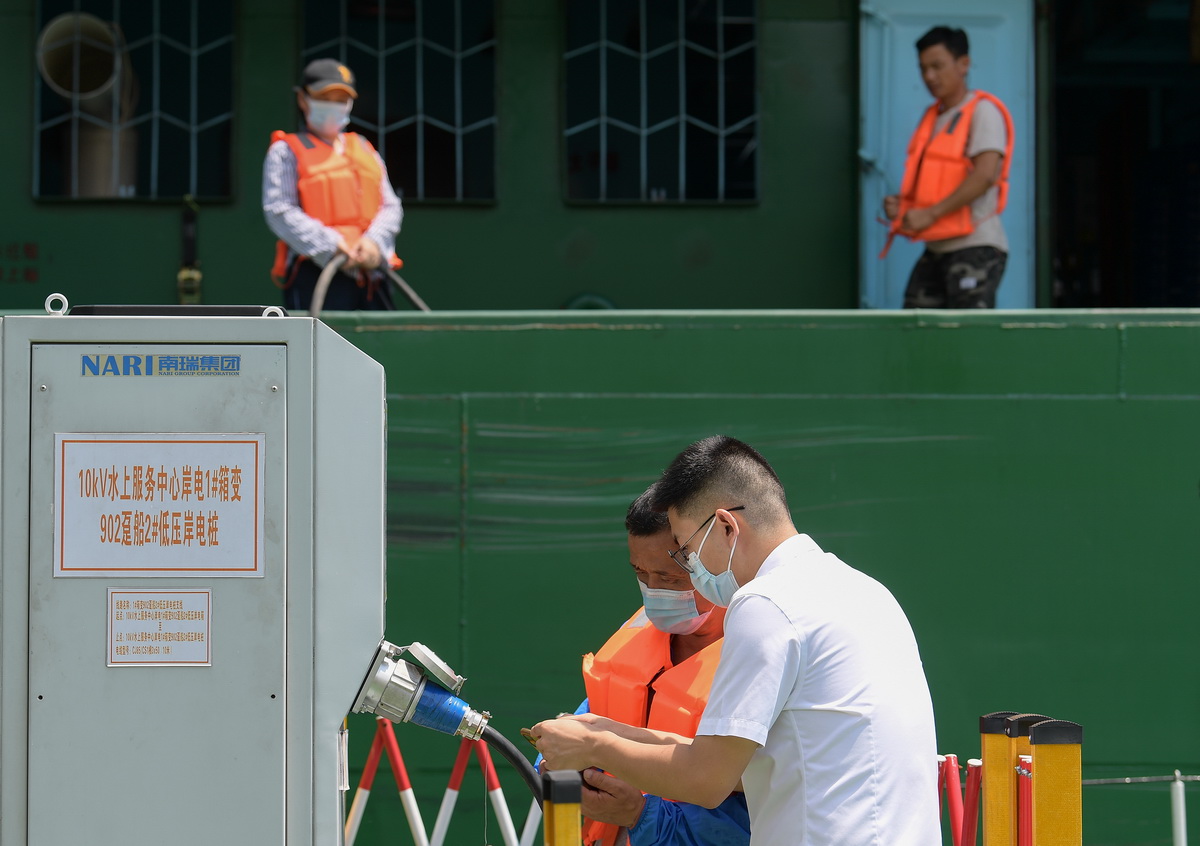 8月9日，长江三峡通航管理局工作人员为船员讲解岸电充电桩的使用方法。新华社记者 李贺 摄