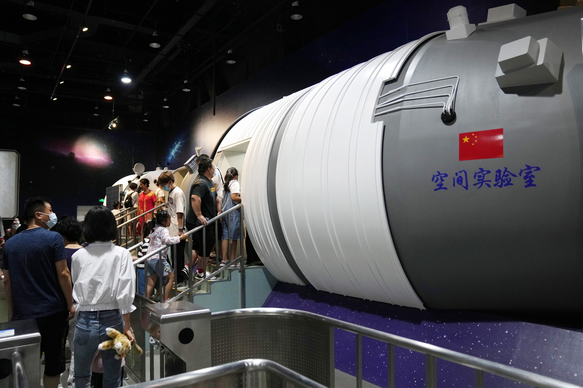 8月14日，在中国科学技术馆，参观者排队参观神舟飞船和空间实验室大型仿真模型。
