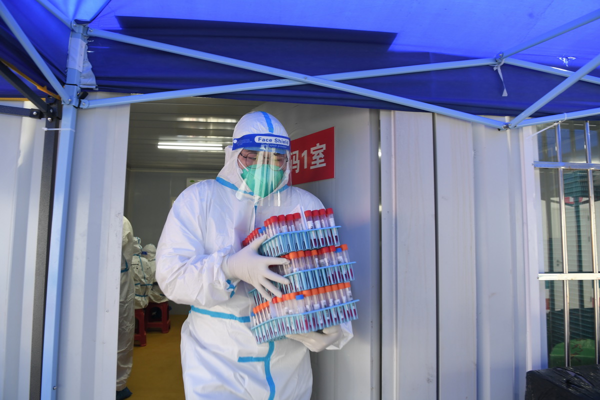 8月14日，在三亞市美麗之冠大劇院的核酸檢測實驗室，檢測員運送核酸樣本。