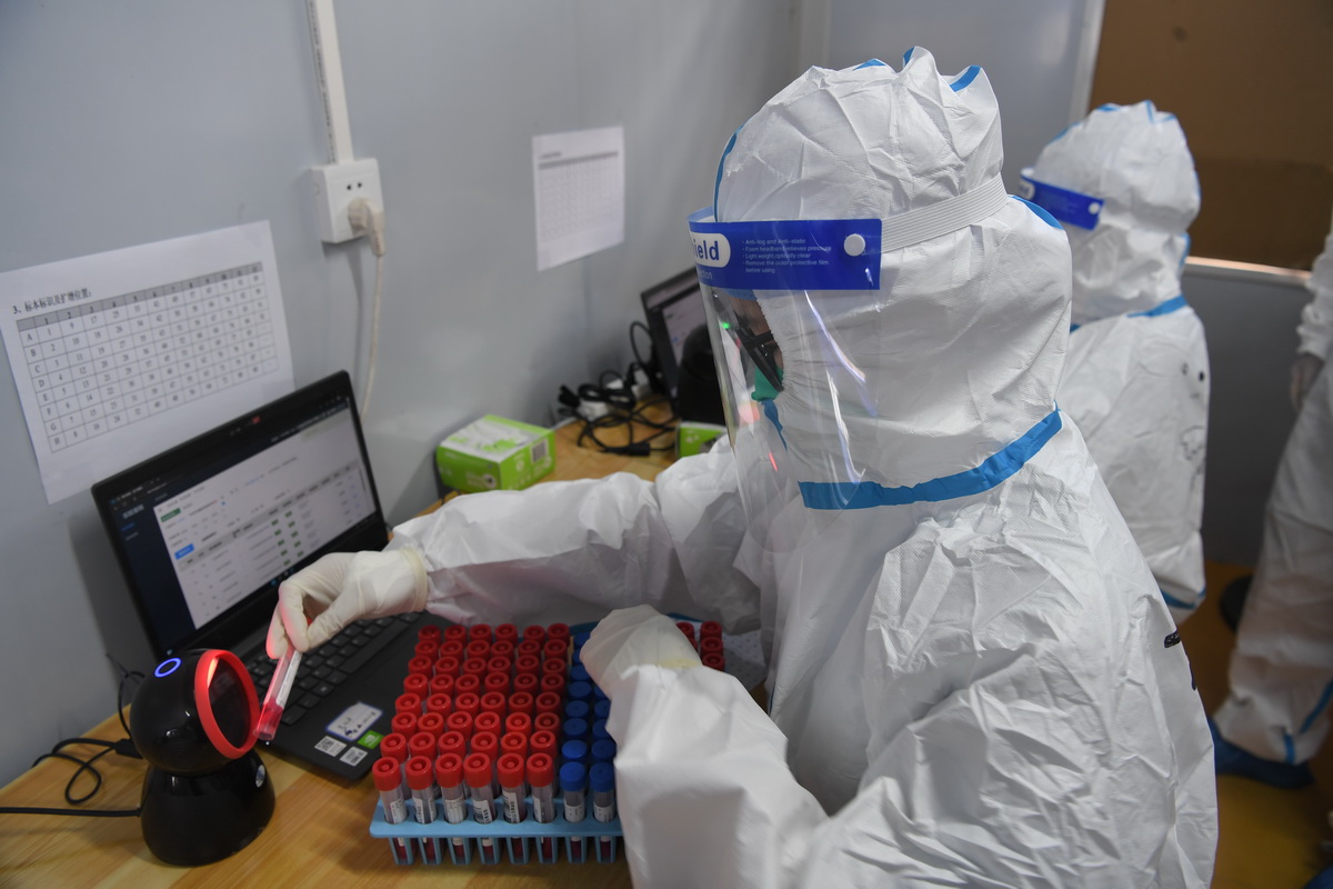 8月14日，在三亞市美麗之冠大劇院的核酸檢測實驗室，檢測員對核酸樣本掃碼。
