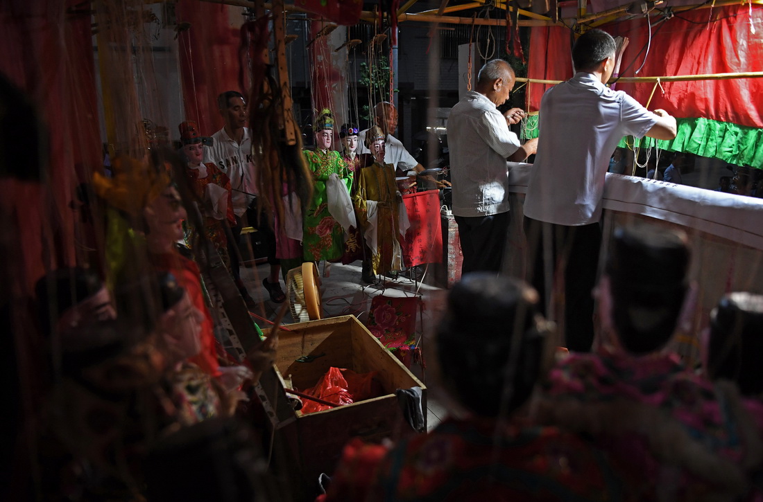 在江西省广昌县塘坊镇大株村，木偶剧团成员在表演木偶戏（8月10日摄）。