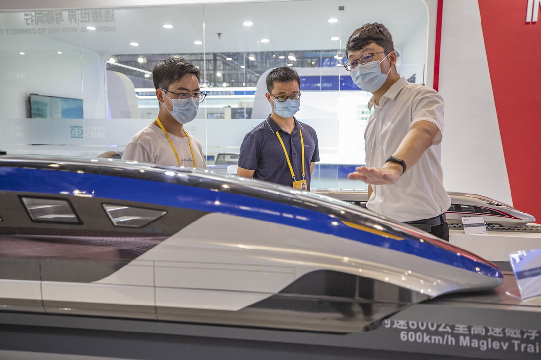 8月22日，在2022智博會中國中車展廳，工作人員（右）向嘉賓介紹時速600公裡高速磁懸浮交通系統。新華社記者 黃偉 攝