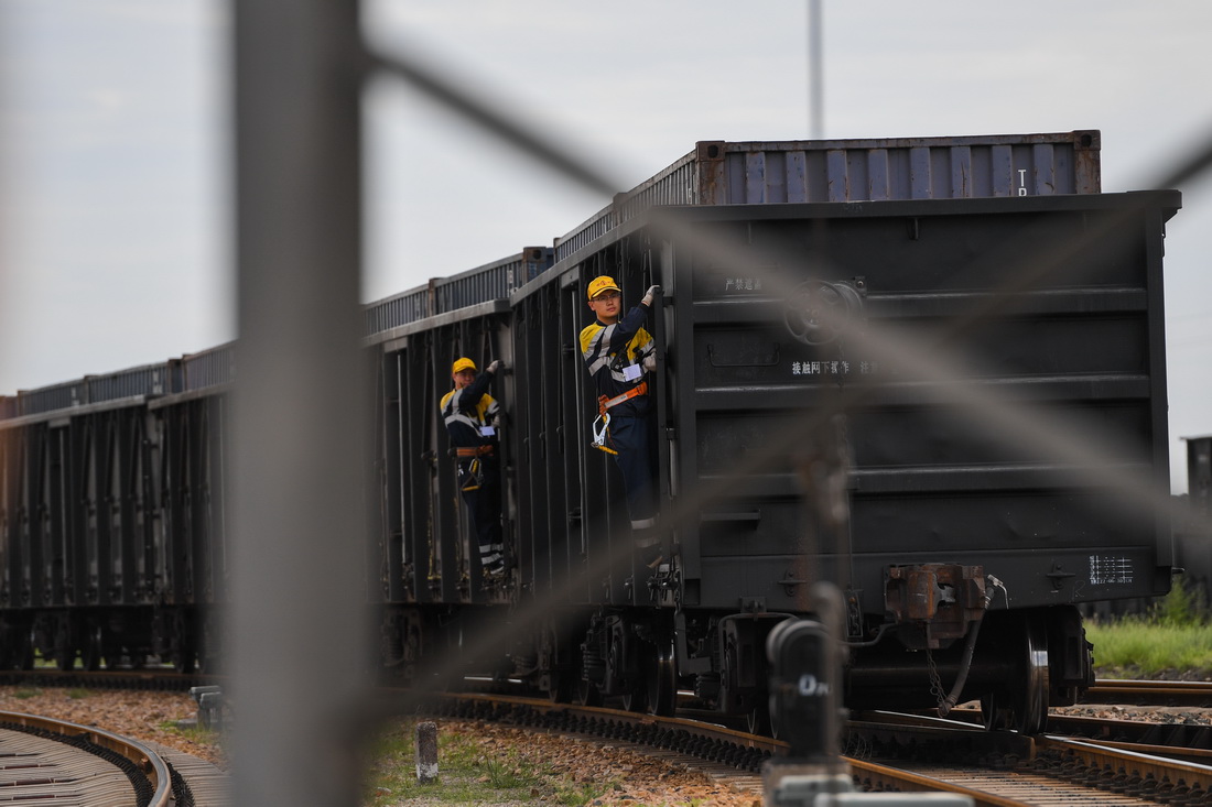8月22日，在烏海西站編組場，調車員在列車行進時觀察線路。