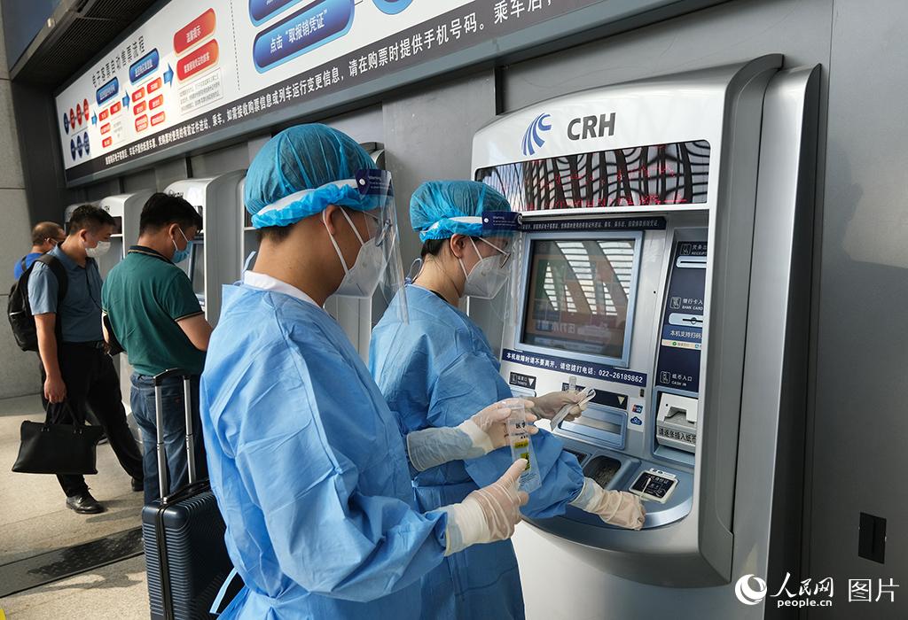 8月23日，天津鐵路疾控中心防疫人員在天津西站對公共區域自助售票機進行環境核酸採樣。