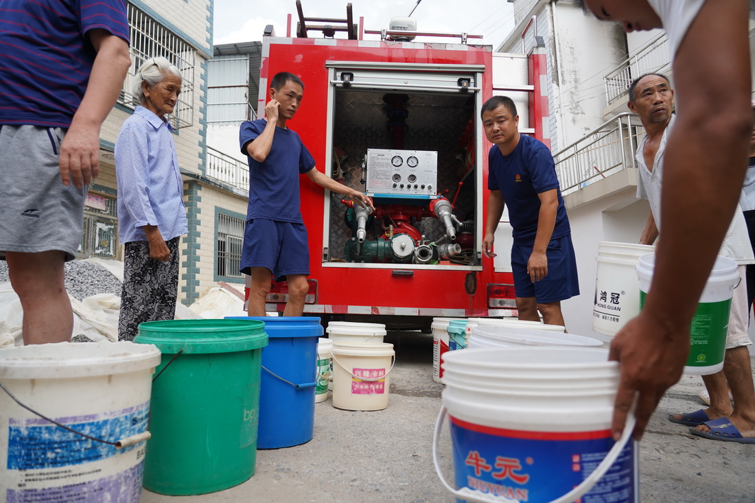 消防员在瑞昌市范镇中源村送水（8月23日摄）。