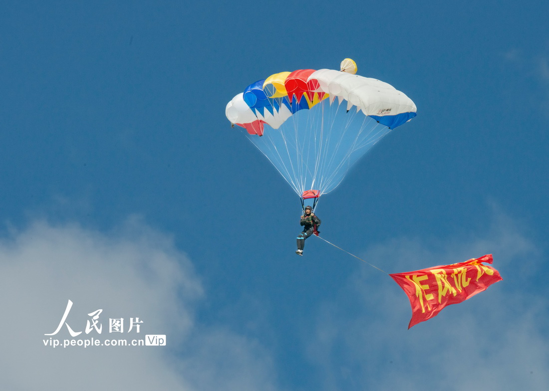 8月27日，空軍航空開放活動暨長春航展第二天，人們在觀看跳傘表演。劉國興攝（人民圖片網）