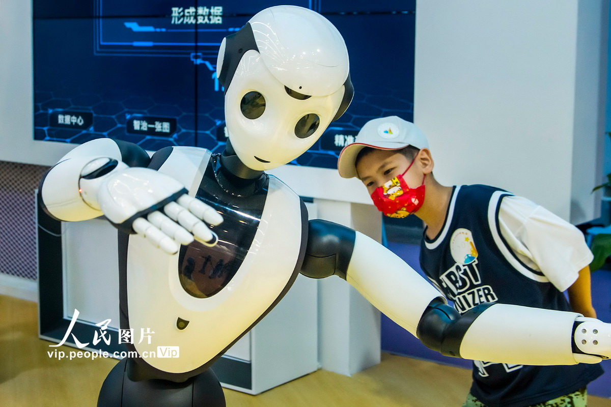 9月3日，小朋友在浙江省宁波国际会展中心观看跳舞机器人。