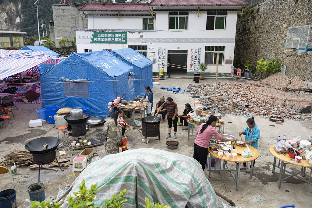 9月7日，在雅安市石棉县王岗坪彝族藏族乡幸福村村委会小广场，村民们搭起帐篷吃住在一起（无人机照片）。