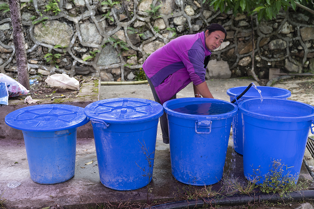 9月7日，在雅安市石棉县王岗坪彝族藏族乡幸福村二组，一名村民在接山泉水，这股山泉水是村民们从山上引下来的。