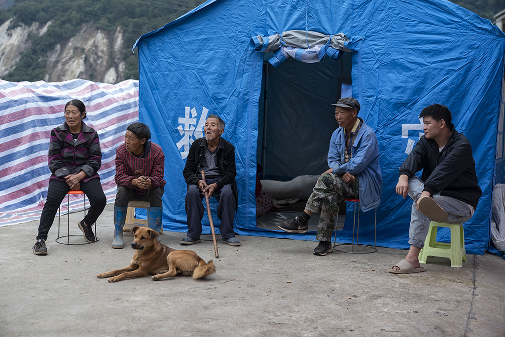 9月7日，在雅安市石棉县王岗坪彝族藏族乡幸福村二组，村民们在帐篷外休息。