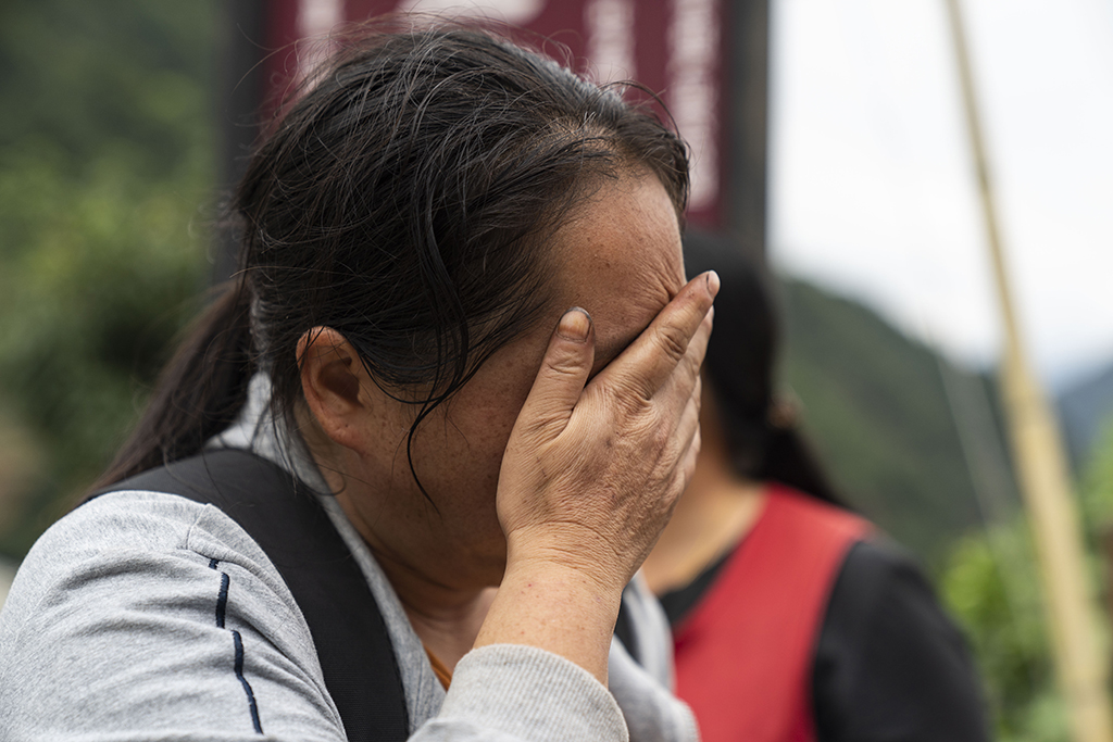 9月7日，在雅安市石棉县王岗坪彝族藏族乡幸福村二组，一名村民在哭泣。