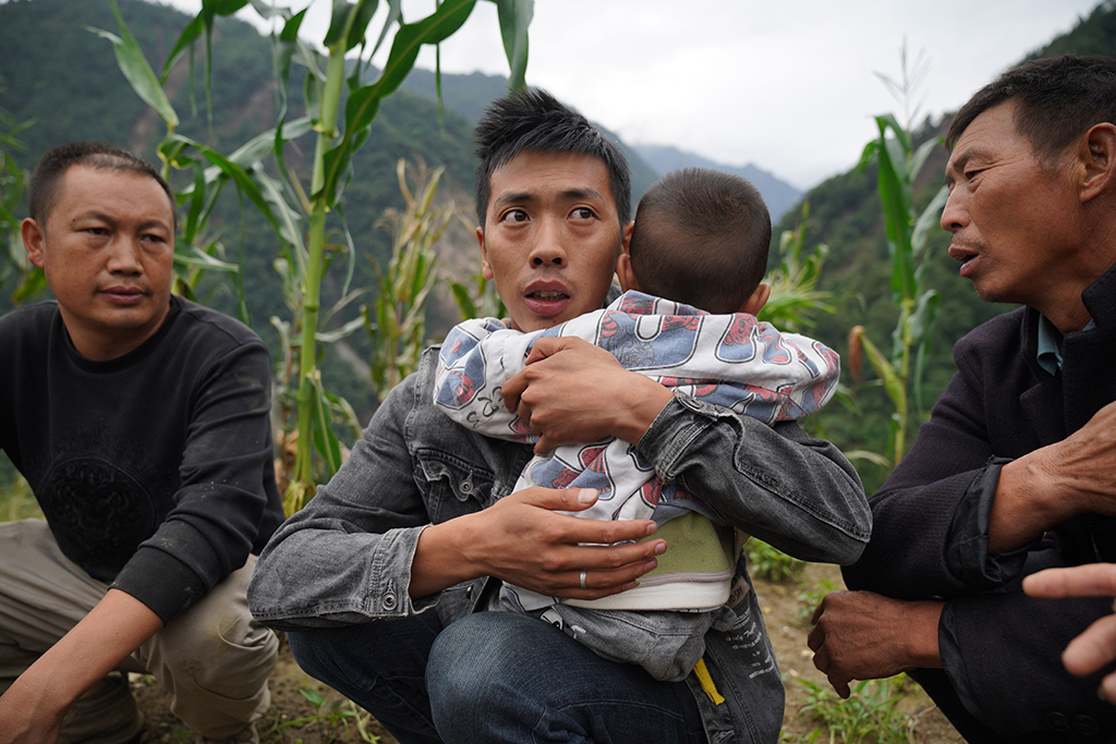 9月7日，在雅安市石棉县王岗坪彝族藏族乡幸福村二组，一名男子抱着生病的孩子准备登上直升机去县城。