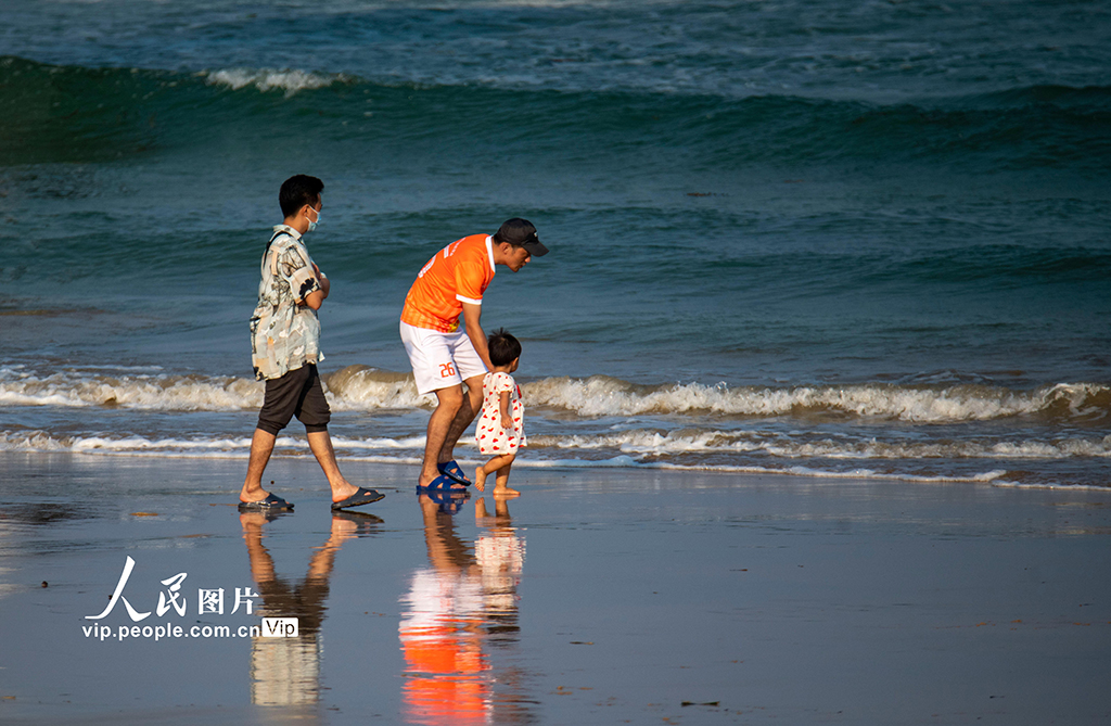 2022年9月11日，海南省琼海市民和游人在博鳌海滨戏水游乐。