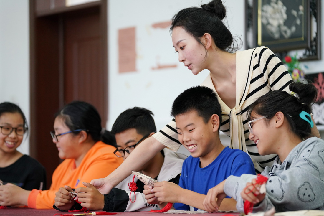9月7日，在黑龙江抚远市乌苏镇抓吉赫哲族村，尚美含指导孩子们制作赫哲族手工艺品。新华社记者 王建威 摄