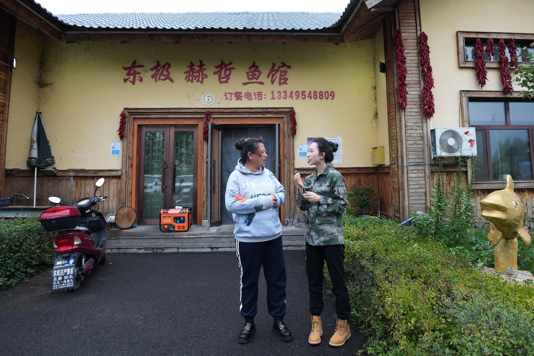 9月7日，尚美含（右）与抓吉赫哲族村的村干部商量第二天的活动事项。新华社记者 王建威 摄