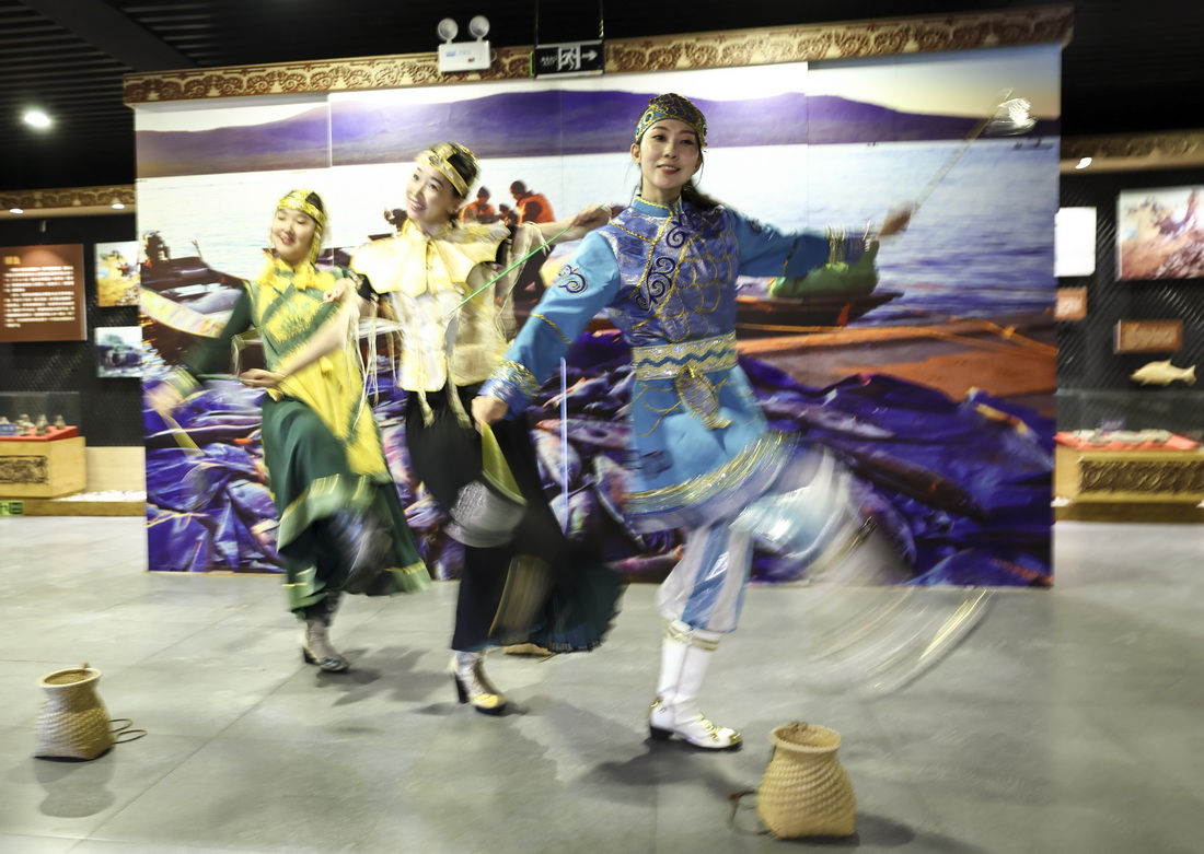 9月4日，在黑龙江抚远市乌苏镇抓吉赫哲族村赫哲民俗展示馆内，尚美含（右一）和赫哲族女孩一起表演民族舞蹈。新华社记者 兰红光 摄
