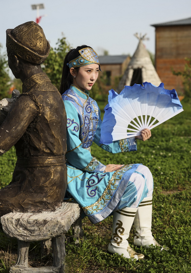 9月4日，在黑龙江抚远市乌苏镇抓吉赫哲族村，尚美含身着赫哲族服装拍摄照片。新华社记者 兰红光 摄