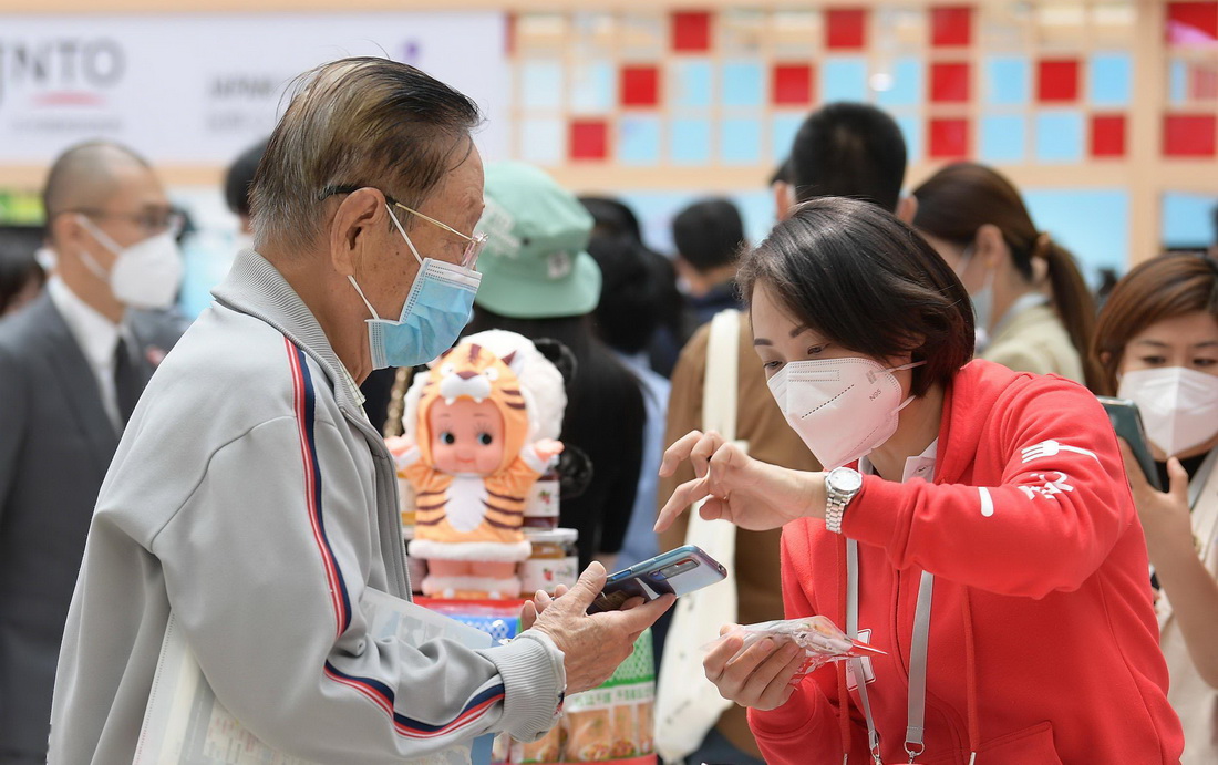9月24日，游客在日本企业展台前咨询。