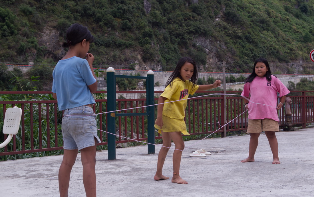 2022年9月14日，怒江州福貢縣托坪村五湖易地扶貧搬遷安置點的小朋友在江邊跳皮筋。新華社記者 岑雲鵬 攝