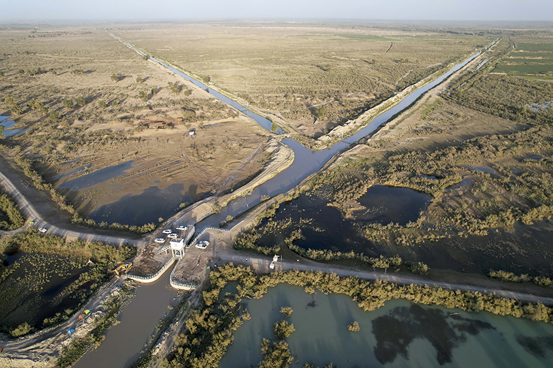 從塔裡木河上游奔涌而來的洪水通過新疆阿克蘇地區沙雅縣沙德克確了生態閘，流向不同方向（2022年8月13日攝，無人機照片）。新華社發（鄒懿 攝）