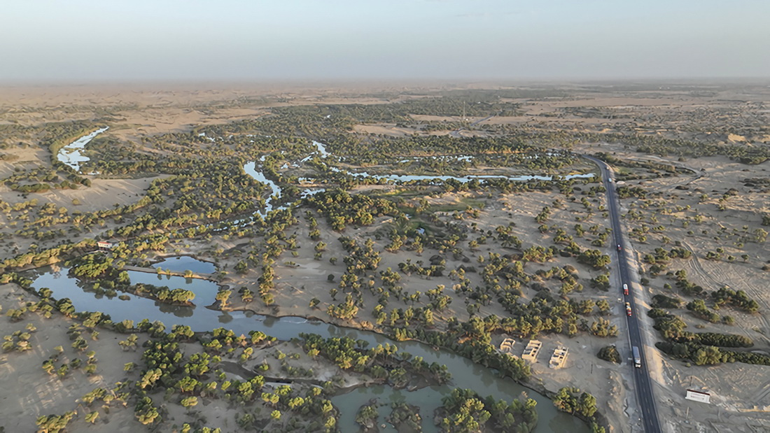 這是2022年8月18日拍攝的塔裡木河下游阿拉干斷面景象（無人機照片）。生態水滋潤兩岸胡楊等植被，同時保障交通要道少受風沙侵襲。新華社發（肖玉磊 攝）