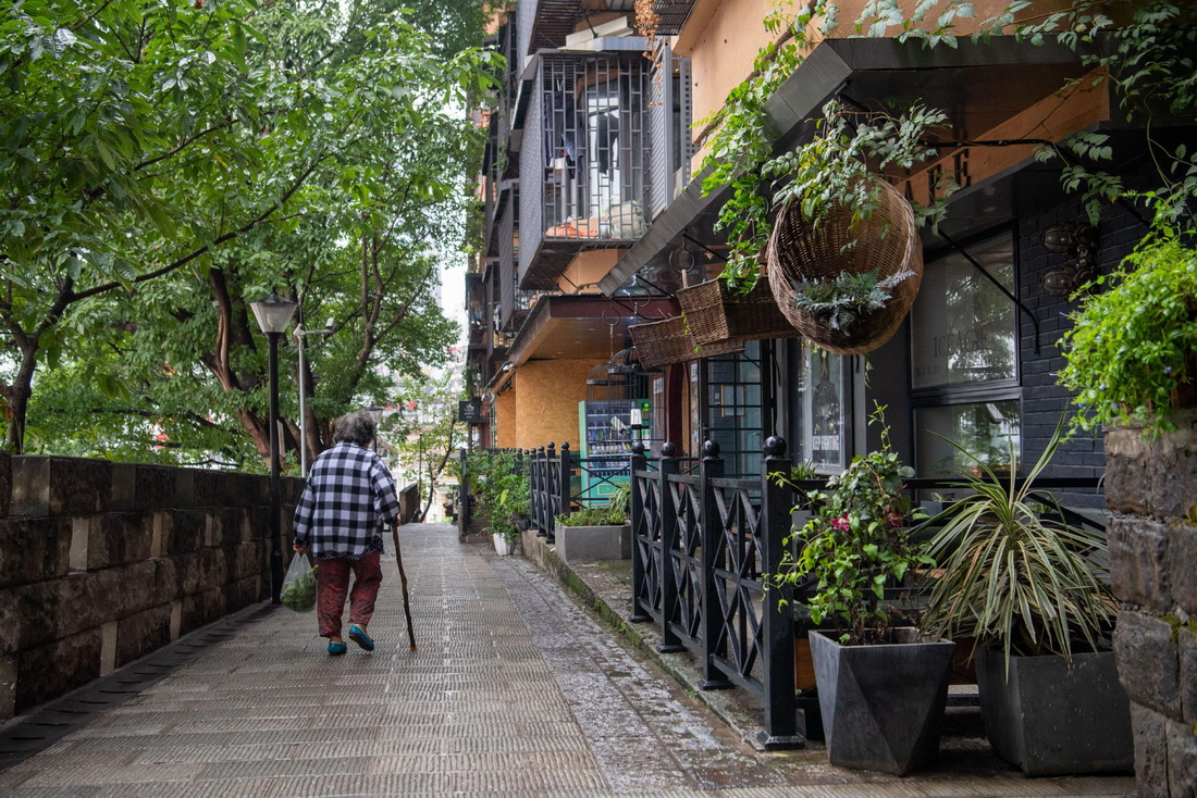 一名市民經過重慶市渝中區戴家巷。該處老社區經過修繕改造，成為深受年輕人和游客喜愛的臨江“咖啡街”（2022年9月24日攝）。