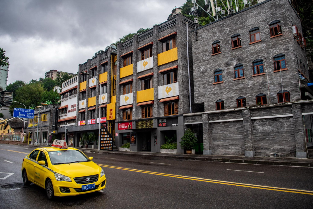 10月6日，在重慶市渝中區一處由老建筑改建的小型商業綜合體“小黃樓”外，一輛出租車在招攬生意。