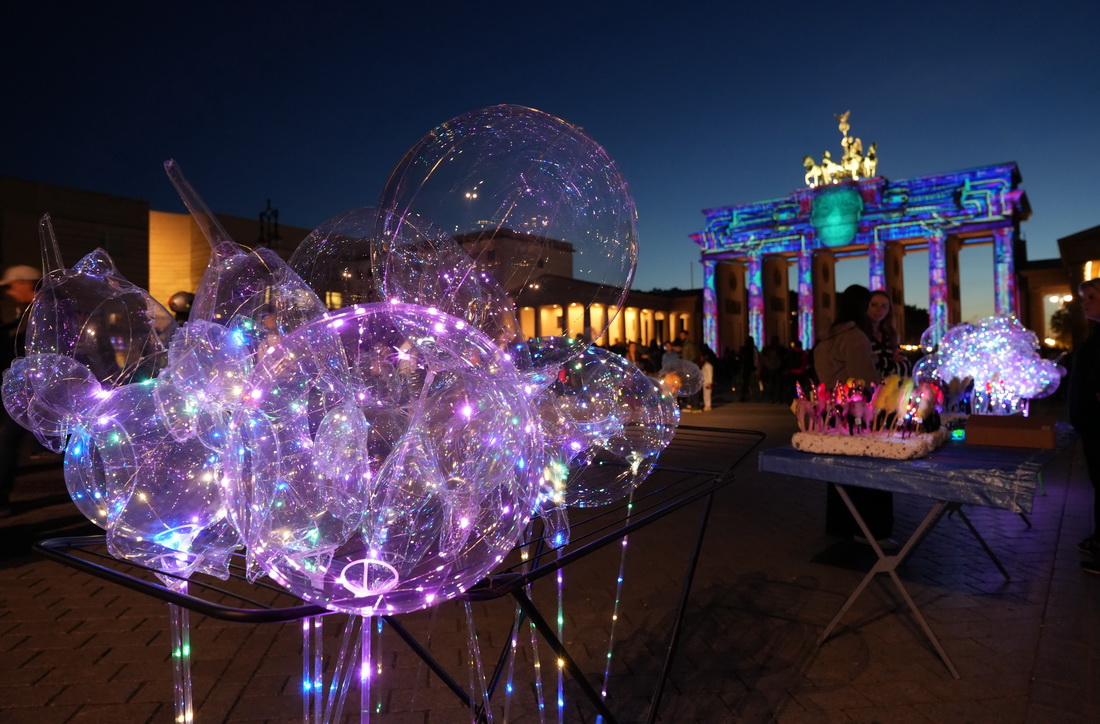 这是10月7日在德国柏林勃兰登堡门前拍摄的用彩灯装饰的气球。