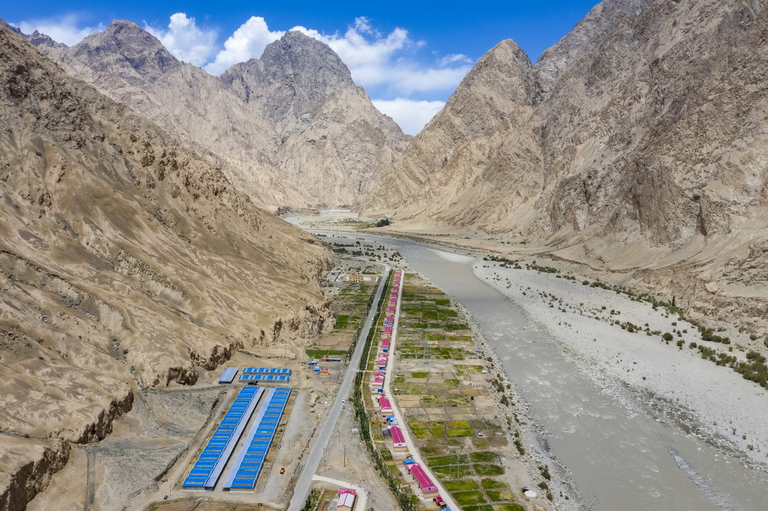 通往縣城的公路從新疆塔什庫爾干塔吉克自治縣大同鄉的一處易地扶貧搬遷安置點旁穿過（2020年6月14日攝，無人機照片）。新華社記者 胡虎虎 攝