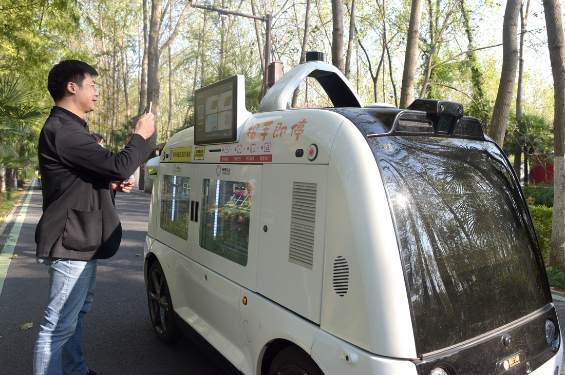 10月11日，在合肥濱湖國家森林公園，一名游客在無人售賣車前掃碼購物。
