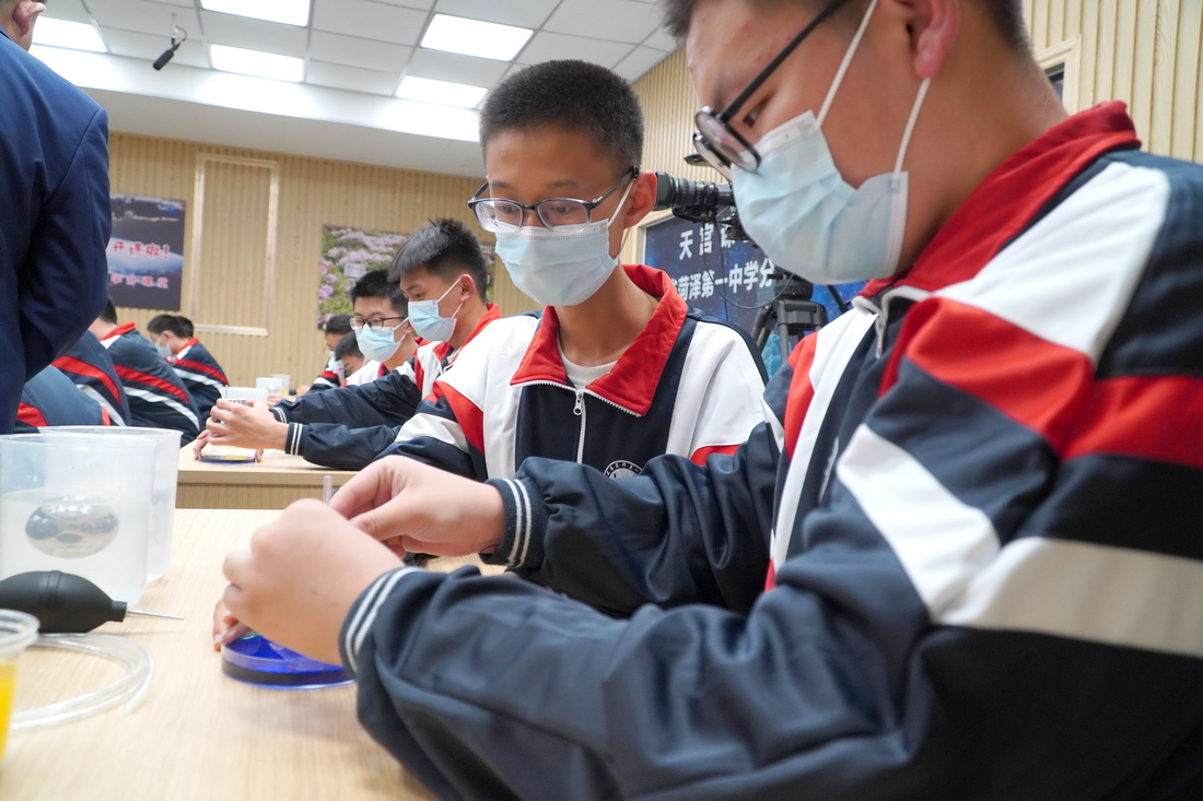 10月12日，學生在山東省菏澤第一中學收看“天宮課堂”第三課時做實驗。新華社記者 徐速繪 攝