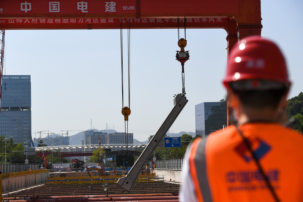 10月26日，在深圳地铁华夏站施工现场，智能龙门吊吊装侧墙预制构件。