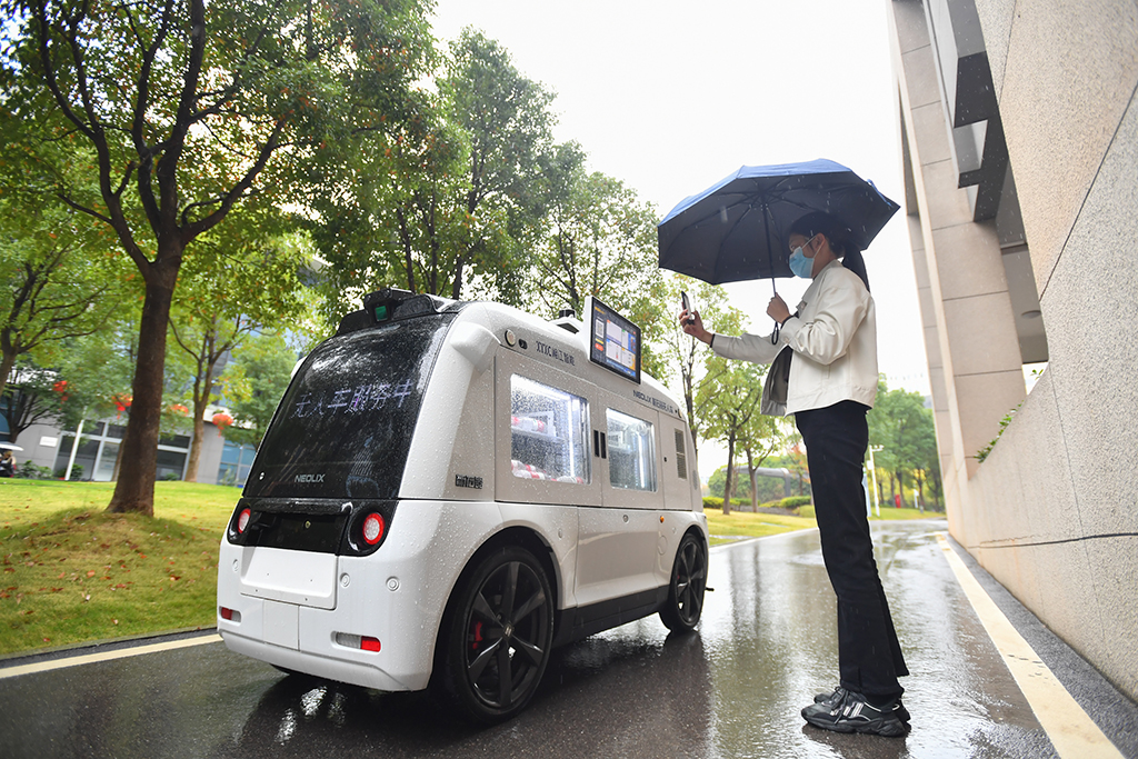 10月27日，在湖南湘江新區的湖南省檢驗檢測特色產業園內，園區員工對著無人駕駛零售車掃碼挑選商品。