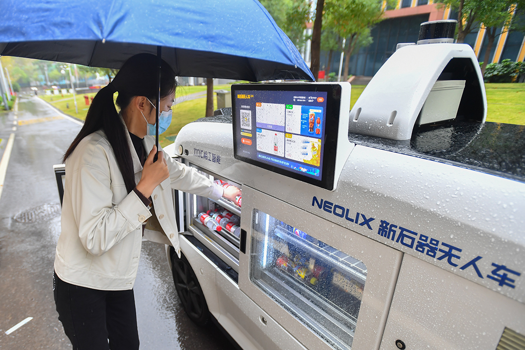 10月27日，在湖南湘江新區的湖南省檢驗檢測特色產業園內，園區員工准備從無人駕駛零售車裡取走剛購買的商品。