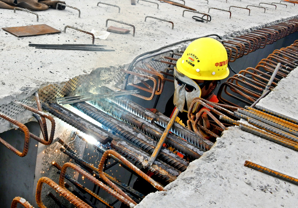 10月30日，一名中鐵十四局建設者在青蘭高速公路雙埠至河套段女姑口特大橋上焊接鋼梁。