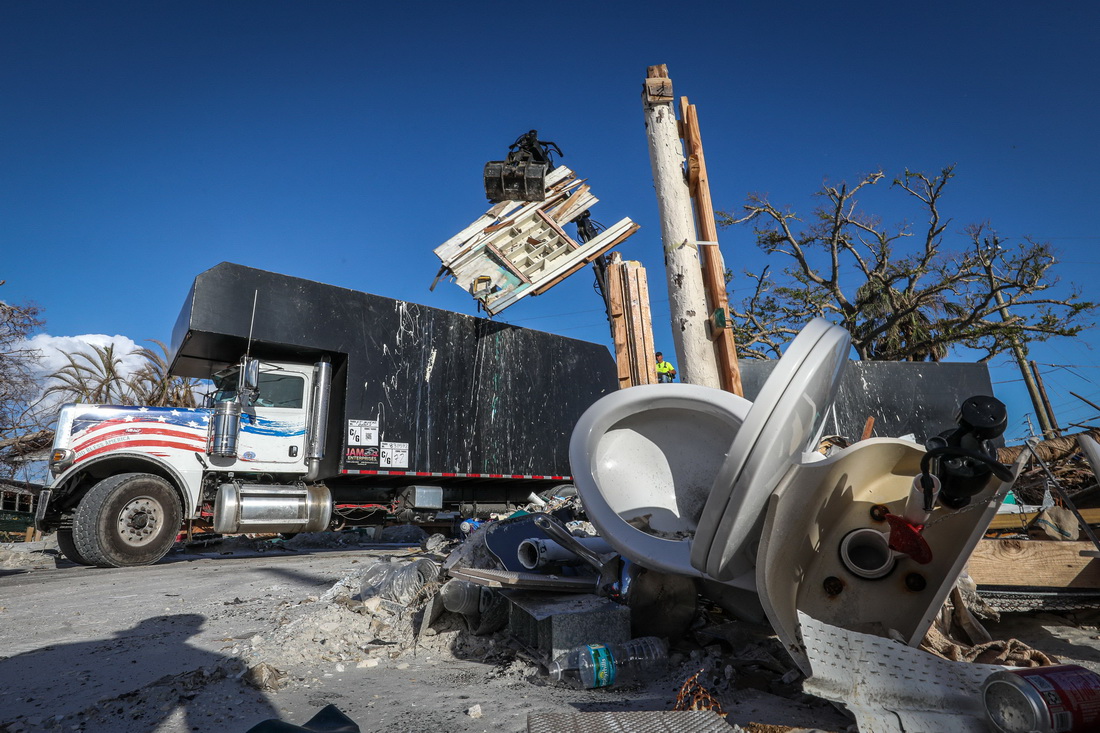 11月7日，一辆吊车在美国佛罗里达州迈尔斯堡海滩附近清理飓风“伊恩”造成的残骸。